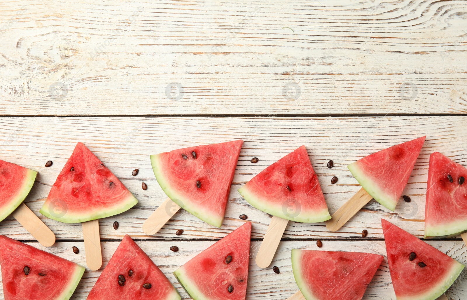 Photo of Slices of ripe watermelon on white wooden table, flat lay. Space for text