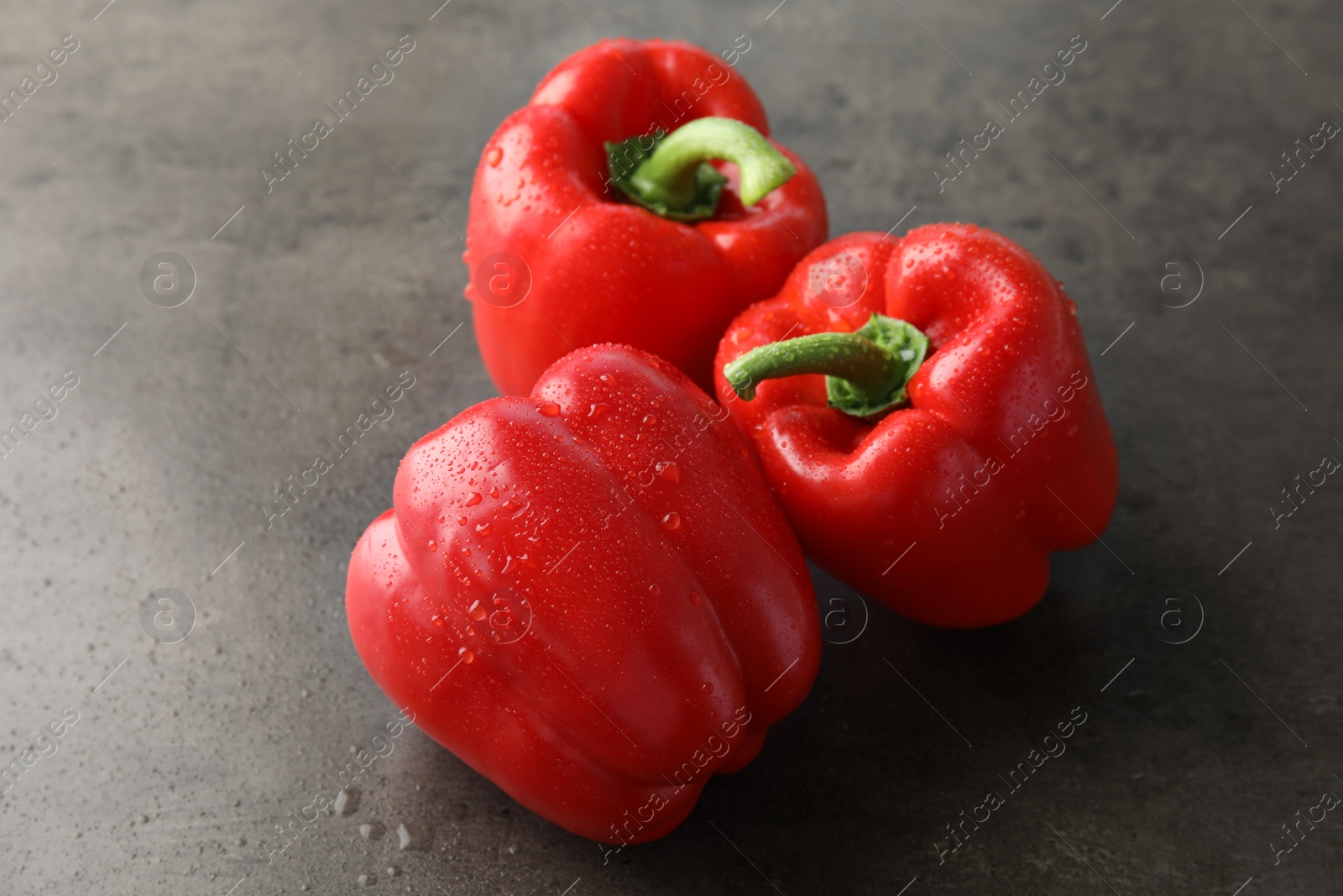 Photo of Raw ripe paprika peppers on grey background