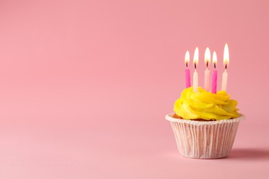 Photo of Tasty birthday cupcake with many candles on pink background. Space for text