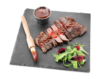 Pieces of delicious roasted beef meat with sauce and greens isolated on white