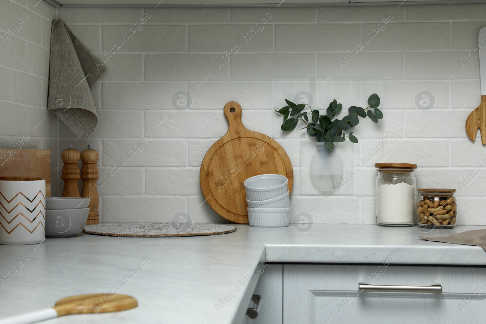 Photo of Silicone vase with eucalyptus branches on wall over countertop in kitchen