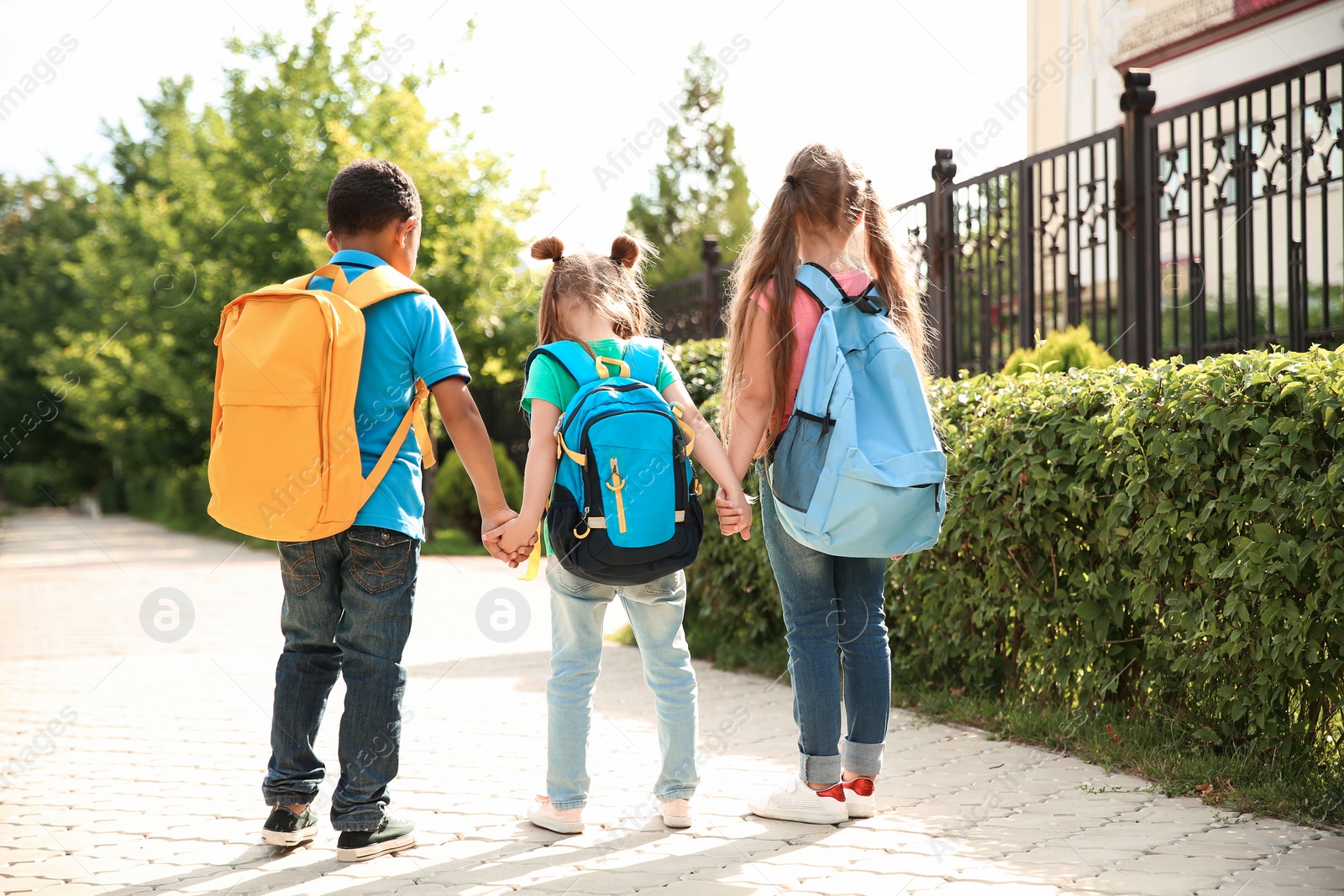 Photo of Cute little children with backpacks going to school