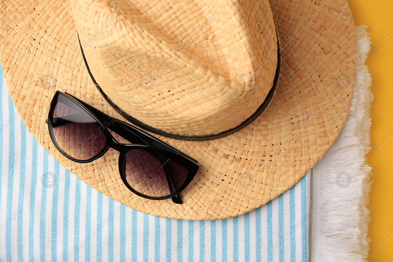 Photo of Flat lay composition with beach accessories on yellow background