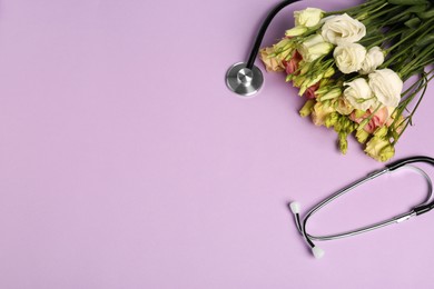 Photo of Stethoscope and flowers on purple background, flat lay with space for text. Happy Doctor's Day