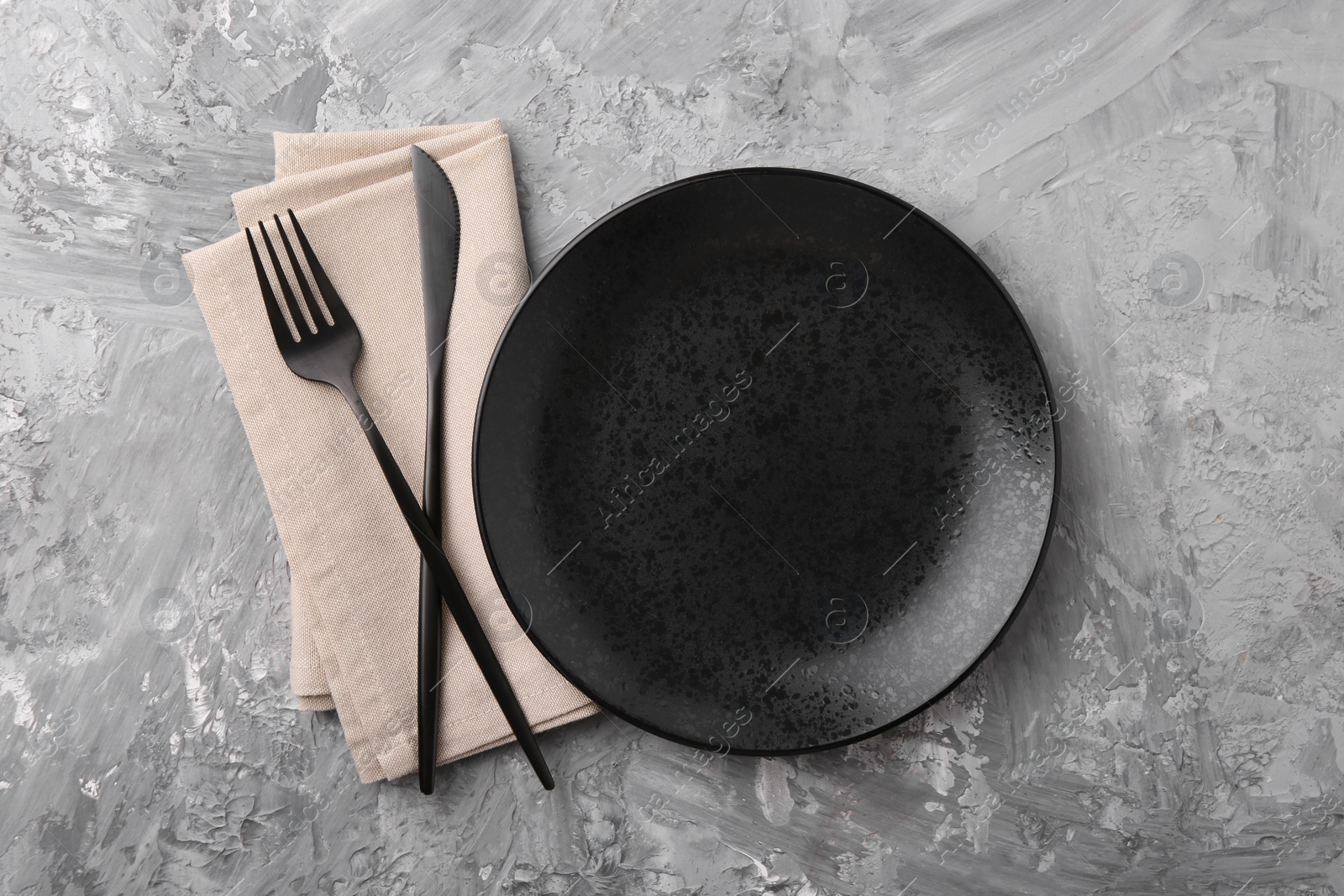 Photo of Elegant setting with stylish cutlery on grey textured table, flat lay