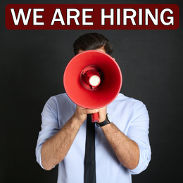Image of Man with megaphone and phrase WE ARE HIRING on black background. Career promotion