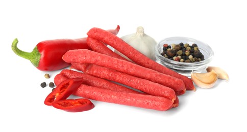 Photo of Thin dry smoked sausages and different spices isolated on white