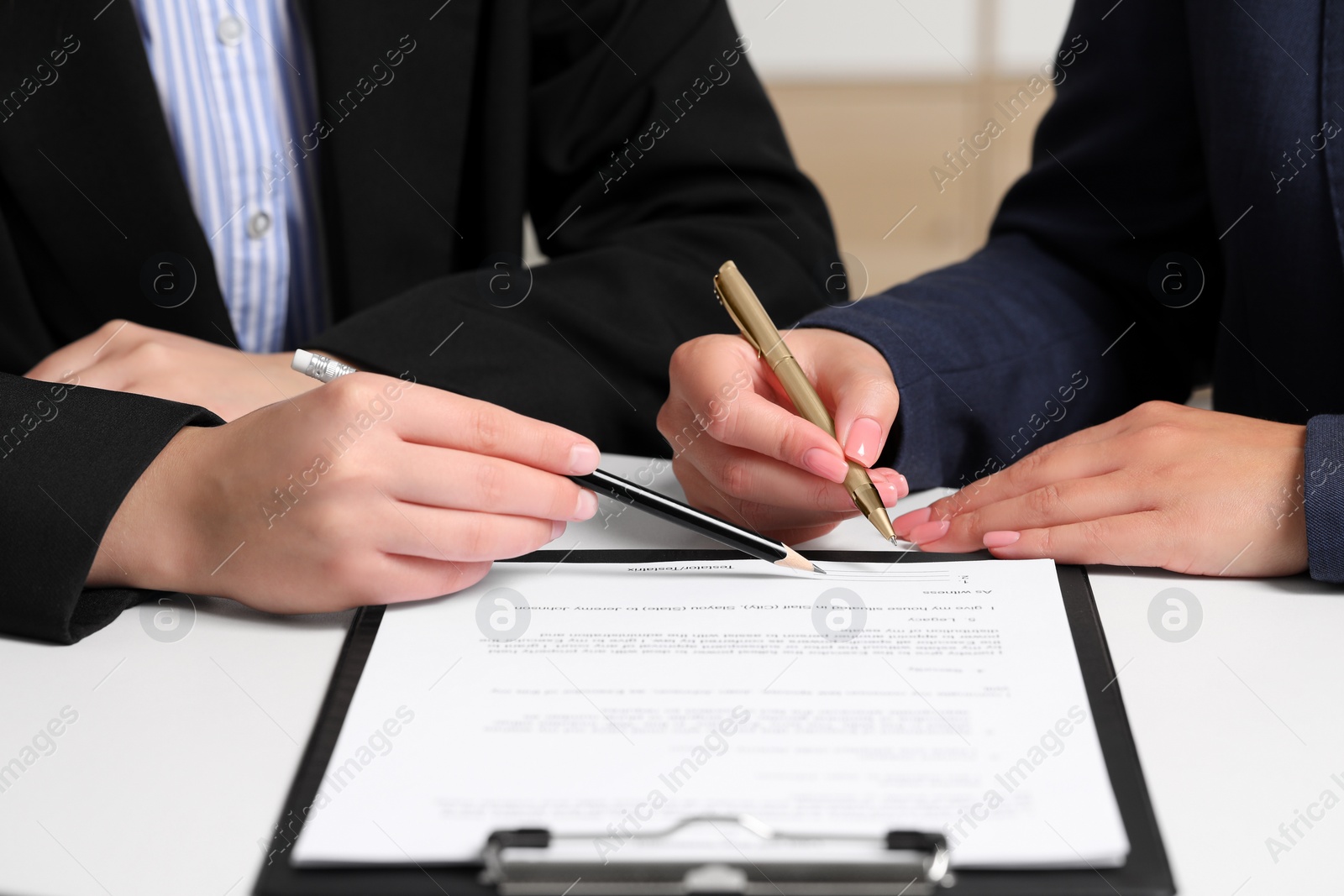 Photo of Businesswoman showing client where to sign document at white table, closeup