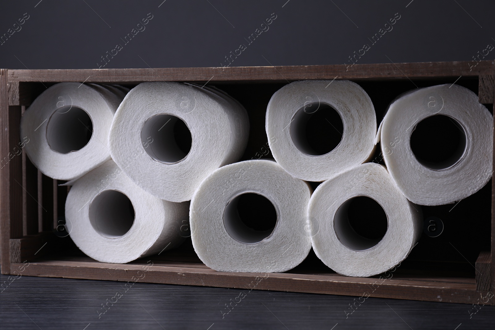 Photo of Toilet paper rolls in crate on wooden table