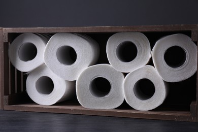 Photo of Toilet paper rolls in crate on wooden table