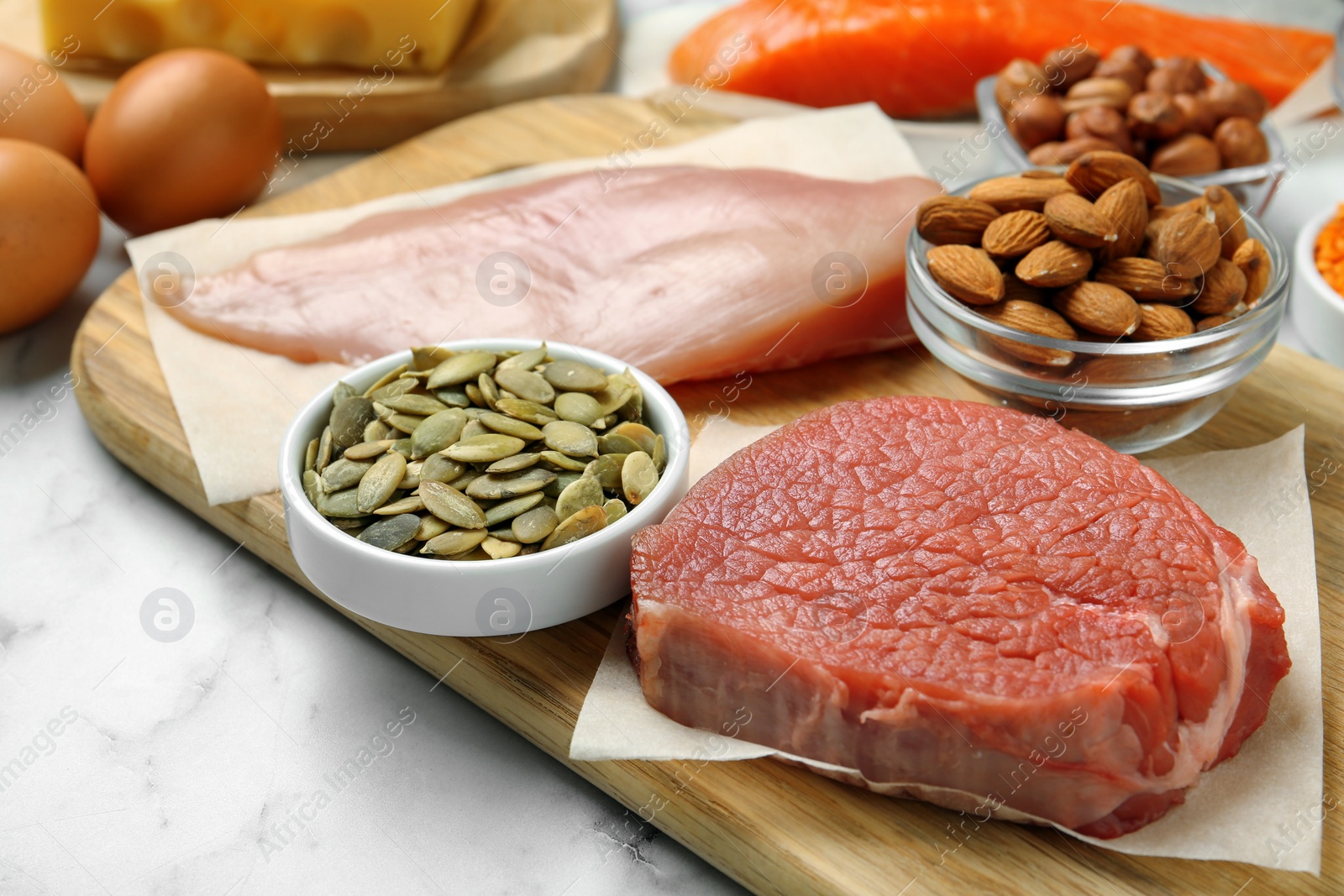 Photo of Fresh meat and other products on white table, closeup. Sources of essential amino acids
