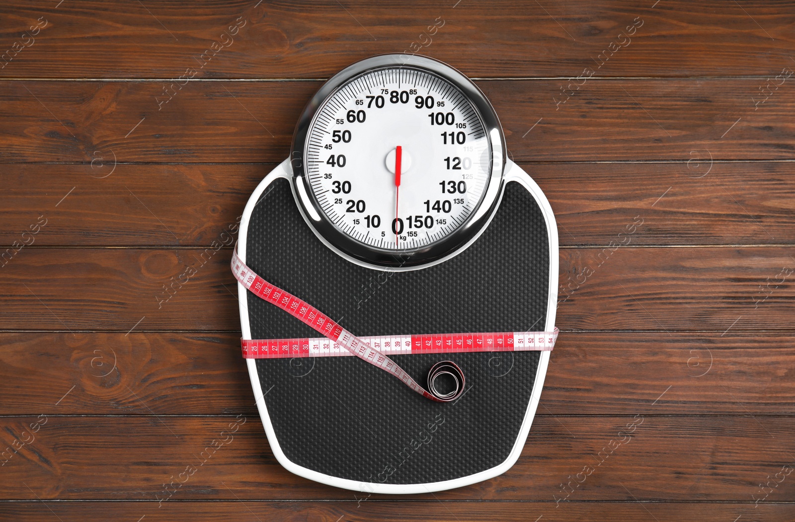 Photo of Scales and measuring tape on wooden background, top view. Weight loss