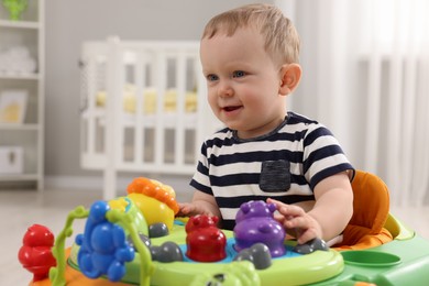 Photo of Portrait of cute baby with toy walker at home. Learning to walk