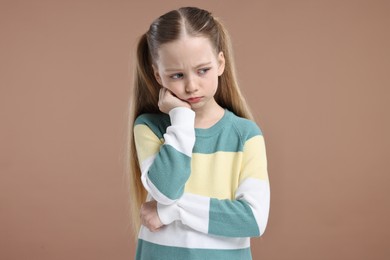 Photo of Portrait of sad girl on light brown background