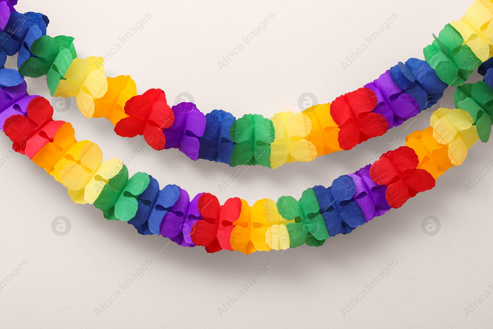 Photo of Rainbow paper garland on beige background. LGBT pride