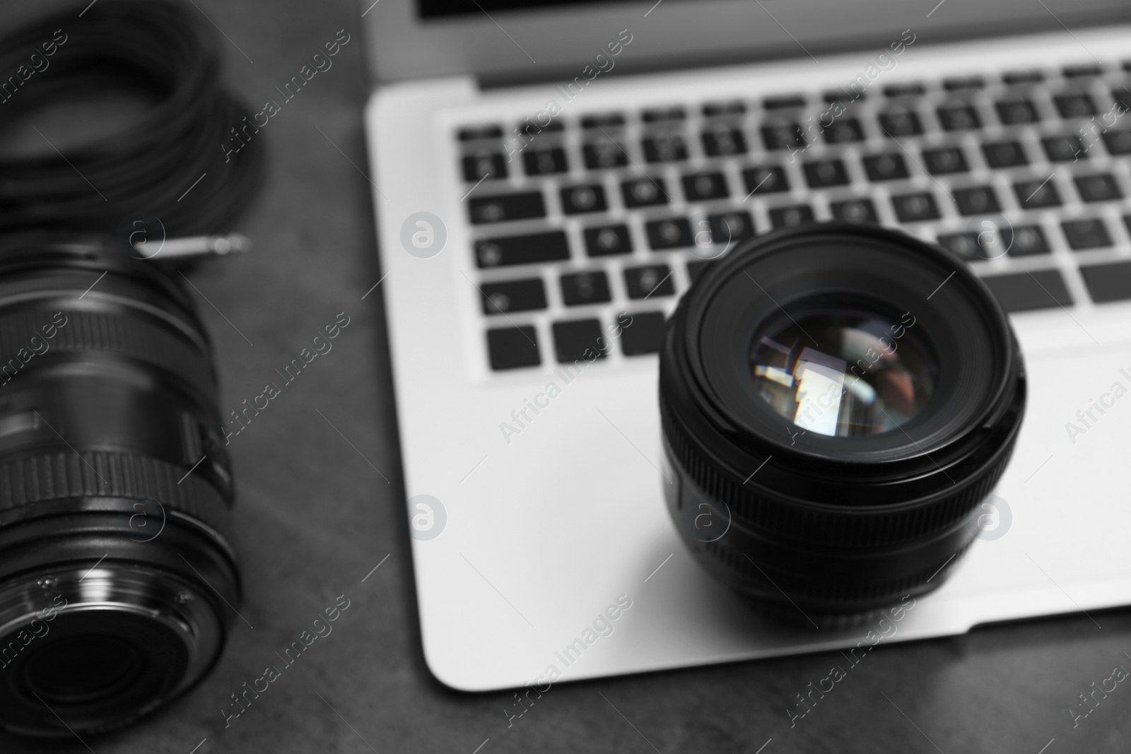 Photo of Professional photographer equipment and laptop on table
