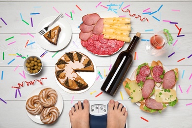 Woman using scale surrounded by food and alcohol after party on floor, top view. Overweight problem