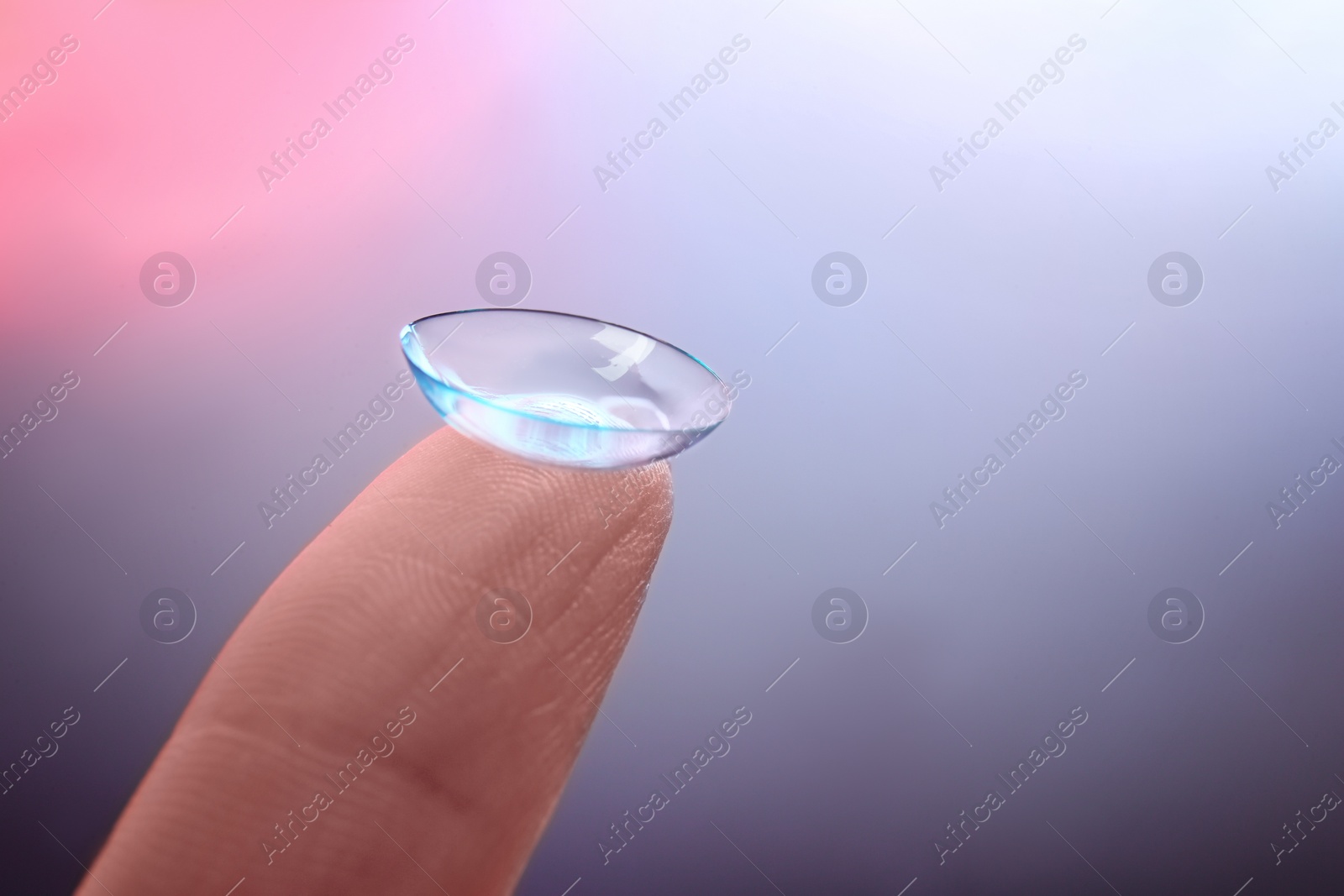 Photo of Woman with contact lens on color background, closeup