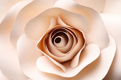 Beautiful beige flower made of paper as background, top view