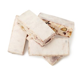 Photo of Many pieces of delicious nougat on white background, top view