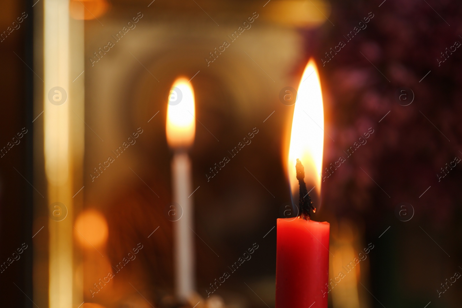 Photo of Red burning candle in church, closeup. Space for text
