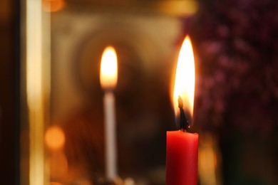 Photo of Red burning candle in church, closeup. Space for text