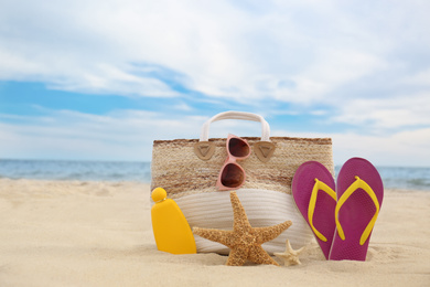 Different stylish beach objects and starfishes on sand near sea