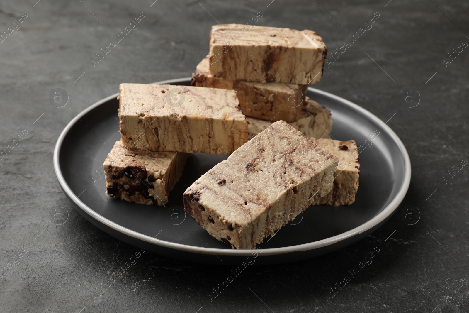 Photo of Plate with tasty chocolate halva on black table