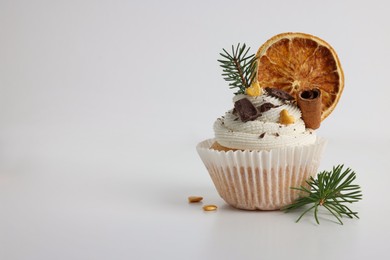 Photo of Tasty Christmas cupcake with cream and decor on white background, space for text