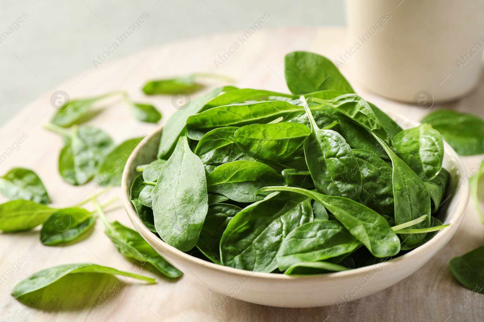 Photo of Bowl of fresh green healthy spinach on table