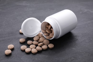 Photo of Plastic jar with brewer's yeast tablets on black table