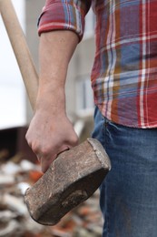 Photo of Man with sledgehammer on blurred background, closeup