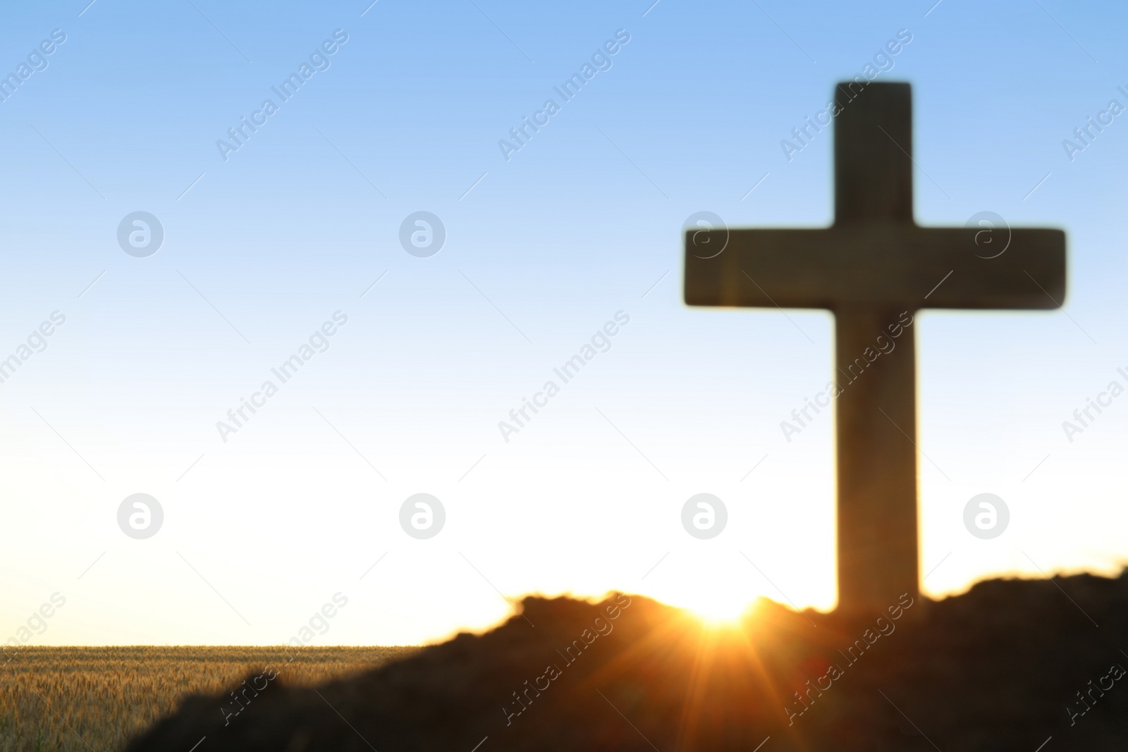 Photo of Wooden Christian cross outdoors at sunrise, space for text. Religion concept