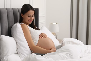 Photo of Beautiful pregnant woman in bed at home