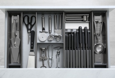 Drawer with stainless steel utensil set, top view. Order in kitchen