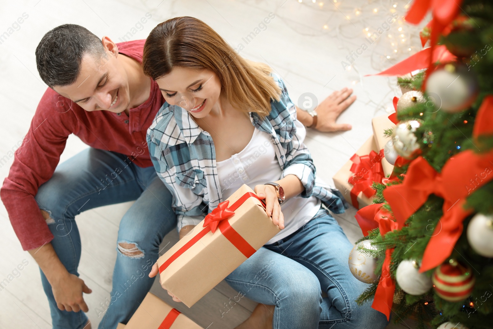 Photo of Young couple with Christmas gift at home