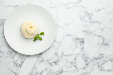 Photo of Delicious burrata cheese with basil on white marble table, top view. Space for text