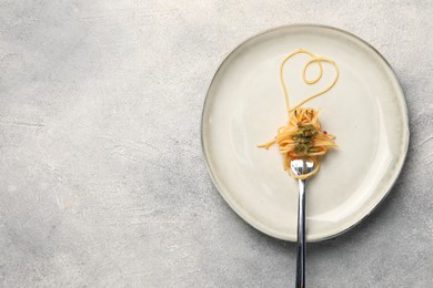 Photo of Heart made with spaghetti and fork on grey table, top view. Space for text