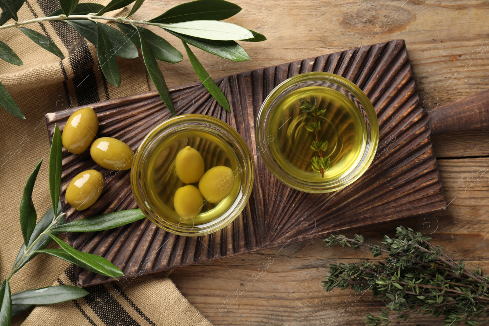 Photo of Flat lay composition with cooking oil and fresh olives on wooden table