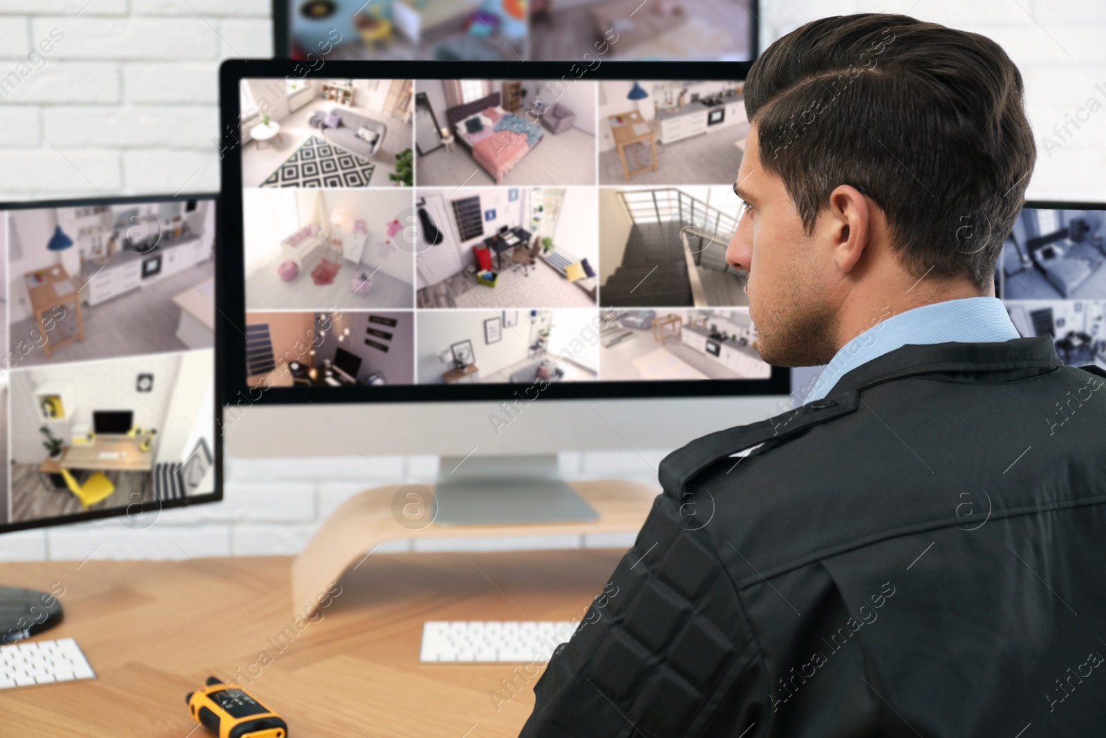 Photo of Male security guard monitoring cameras at workplace