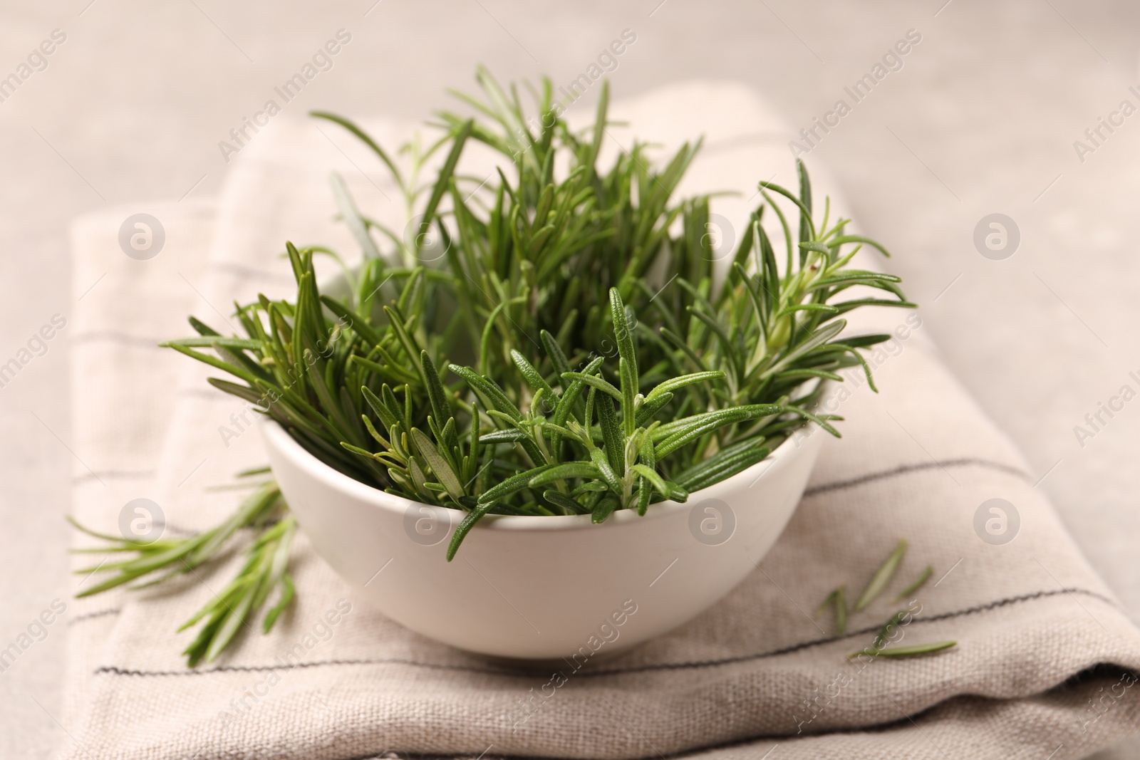 Photo of Bowl with fresh green rosemary on light table