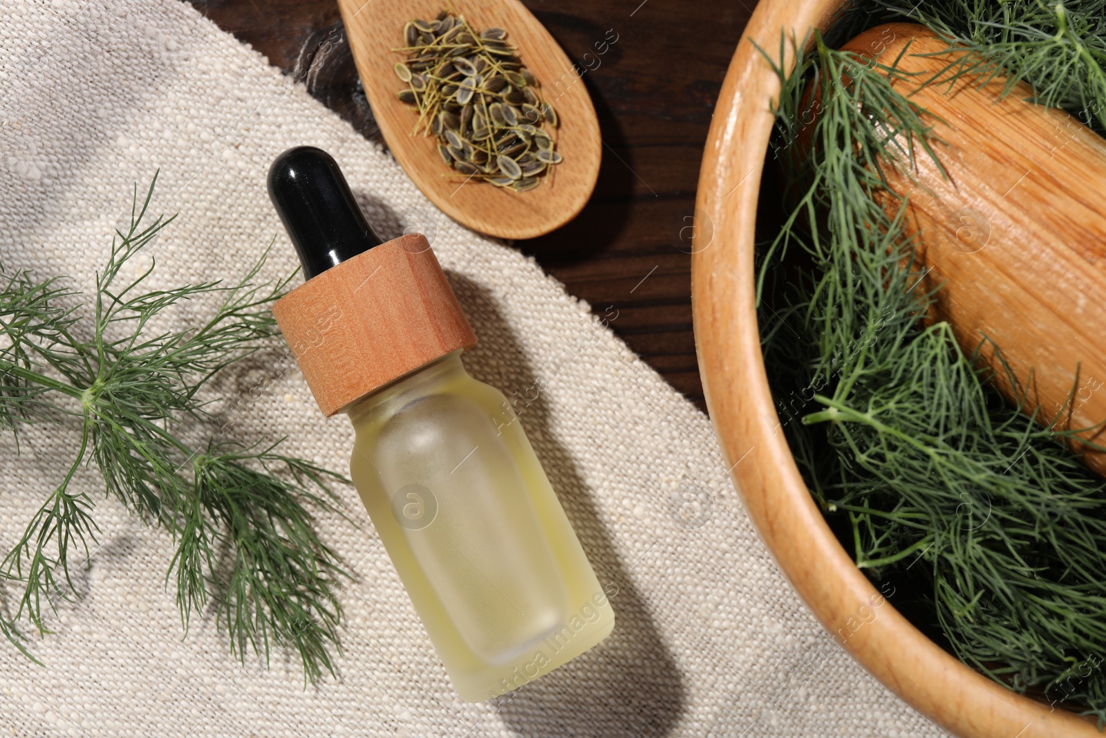 Photo of Bottle of essential oil and fresh dill on table, flat lay