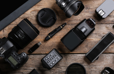 Photo of Flat lay composition with equipment for professional photographer on wooden table