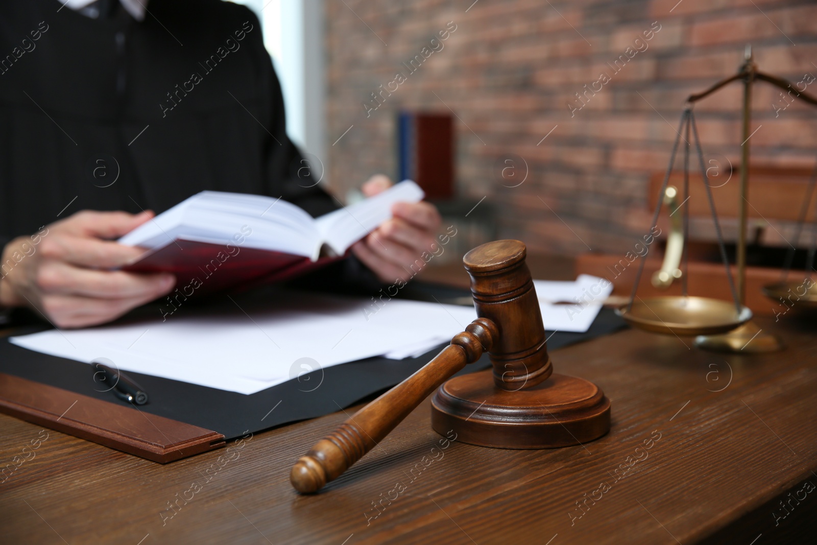 Photo of Judge working at table in office, focus on gavel. Law and justice concept