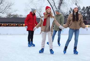 Image of Group of friends skating at outdoor ice rink