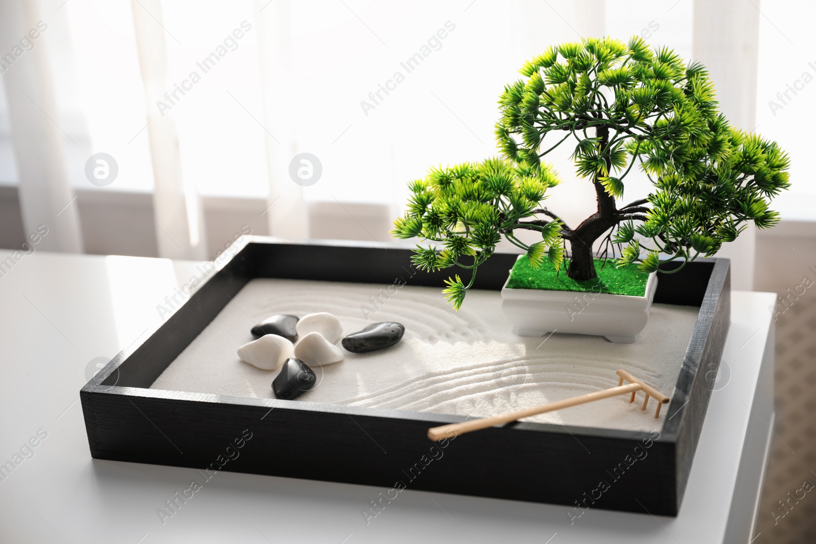 Photo of Beautiful miniature zen garden on white table indoors