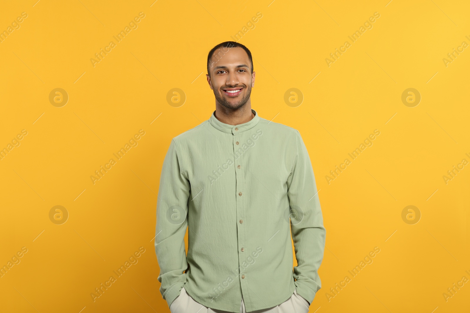 Photo of Portrait of handsome young man on orange background