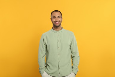 Portrait of handsome young man on orange background