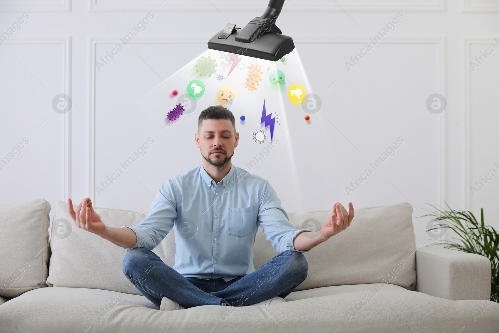 Image of Purification of mind. Vacuum cleaner extracting bad thoughts from meditating man on sofa indoors