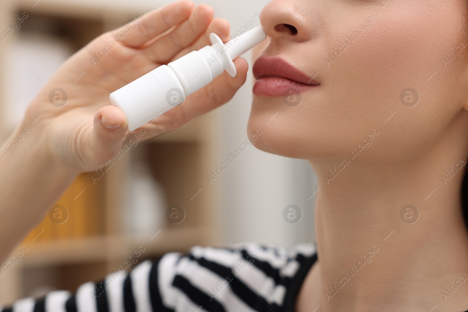 Photo of Medical drops. Woman using nasal spray at home, closeup